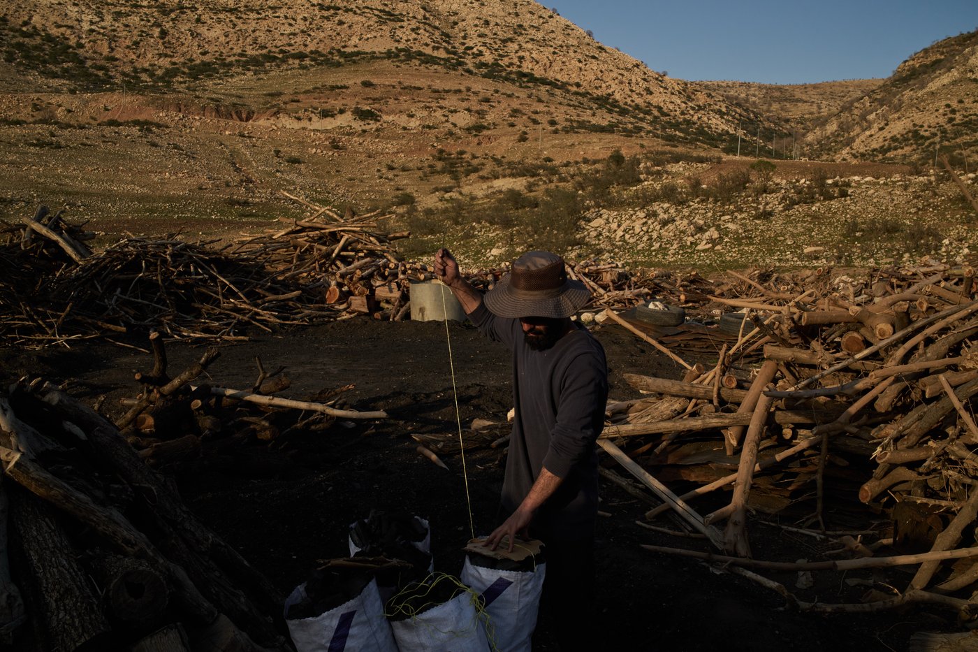 Photos: Charcoal workers in a quiet Kurdish village carry on as war unfolds | iNFOnews.ca