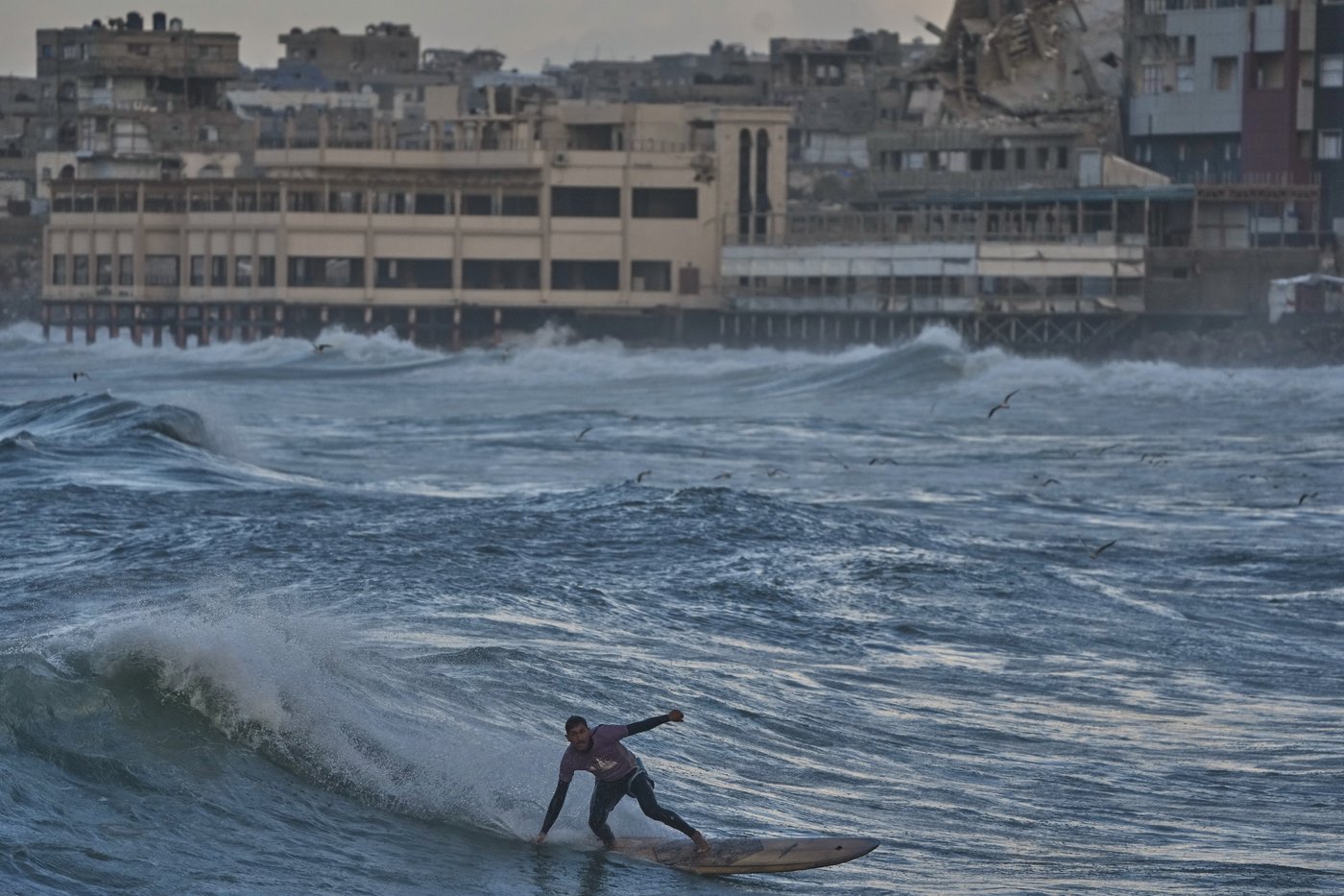 Photos show surfers riding waves along Gaza City’s damaged coastline | iNFOnews.ca